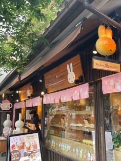 an outside view of a bakery with bunnies hanging from the ceiling