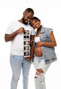 a man and woman pose for the camera with their pregnant bellys in front of them