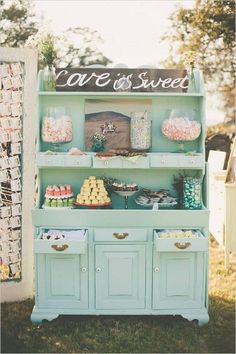 an old china cabinet is decorated with cupcakes and sweets for a sweet tea party