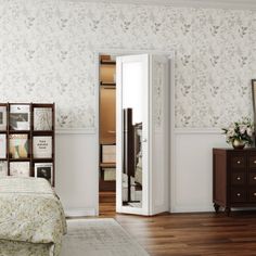 a bedroom with a bed, dresser and mirror in the corner next to a bookcase