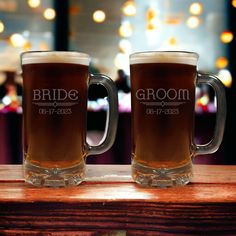 two beer mugs sitting on top of a wooden table