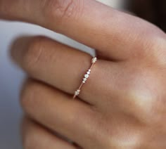 a woman's hand with a diamond ring on her left finger and the other hand holding