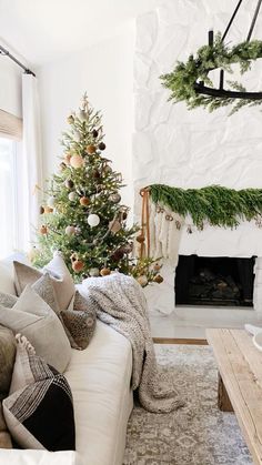 a living room filled with furniture and a christmas tree in front of a fire place