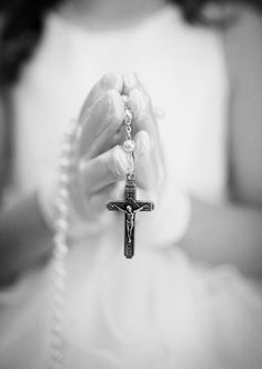 a woman holding a rosary in her hands