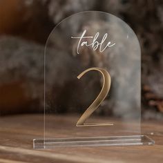 a glass table number holder with the number two on it's front and side