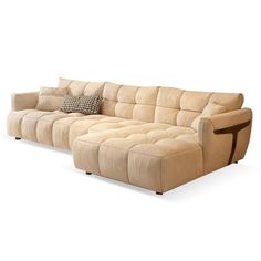 a large sectional sofa with pillows on it's back and side facing the couch