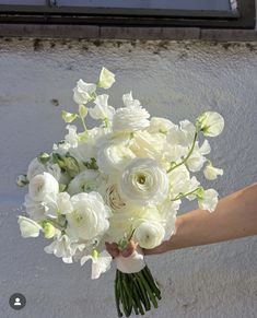 a person holding a bouquet of white flowers