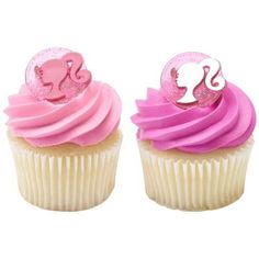 two cupcakes with pink frosting and one has a monogrammed heart on top