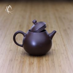 a brown tea pot sitting on top of a wooden table