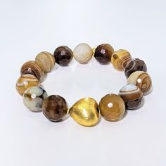 This Ro & Gieo bracelet features stunning banded agate beads paired with a chunky 24 karat gold-plated brass heart. The unique combination of materials offers a luxurious and trendy look, making it the perfect accessory for any occasion. The banded agate beads provide a natural and earthy touch, while the gold-plated heart adds a touch of elegance. Elevate your style with this exquisite bracelet. Ro & Gieo Banded Agate Bead and 24 karat gold-plated 100% brass heart chunky bracelet Beads - 16 mm Chunky Bracelets Beads, Jasper Bead Bracelet, Chunky Bracelet, Chunky Bracelets, Cuff Bangle Bracelet, Banded Agate, Jasper Beads, Cuff Bangles, Agate Beads