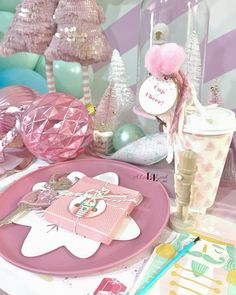 a table topped with lots of pink and white decorations