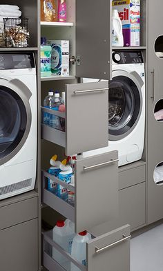 a washer and dryer in a room with shelves on the wall next to each other