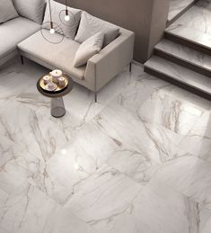 a living room with white marble floors and stairs