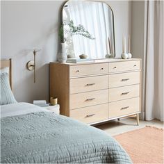 a bedroom scene with focus on the dresser and bed