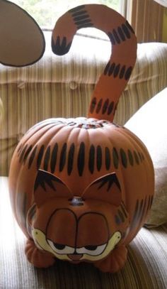 a pumpkin shaped like a tiger sitting on top of a couch