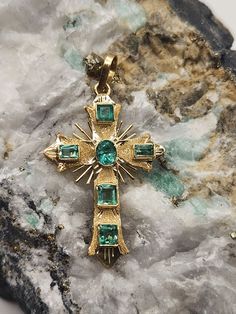 18kt Yellow Gold Cross pendant with Colombian Emerald. - A Touch of Classic Elegance and Brilliant Exclusivity. 1.24 in x 0.8 in Elevate your style with these exquisite 18kt gold cross pendant, featuring stunning Colombian emeralds. Each piece is meticulously crafted to blend timeless sophistication with vibrant, eye-catching beauty. The rich green of the emeralds, renowned for their exceptional clarity and color, contrasts beautifully with the lustrous gold, creating a luxurious and elegant acc Gold Cross Pendant, Colombian Emeralds, Rich Green, Gold Cross, Elegant Accessories, Religious Gifts, Natural Emerald, Classic Elegance, Crystal Items