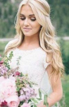 a beautiful blonde woman holding a bouquet of flowers