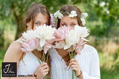 two girls are holding flowers in their hands