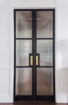 a black double door with glass and gold handles