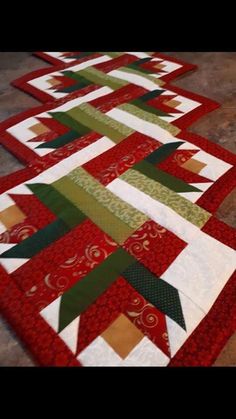 two red and green christmas quilts on the floor