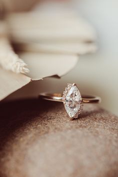 a diamond ring sitting on top of a piece of paper next to a folded napkin