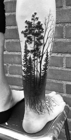 a man's leg with a tree tattoo on it