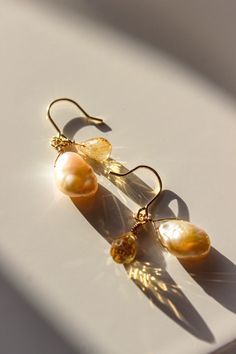 PRODUCT DESCRIPTION Inspired by the seas' motion and the rise and fall of the tide, there's an element of nature in this piece. Complete with a golden natural citrine and a unique pair of baroque pearl droplets, this set of earrings are full of luxurious. You are fine to shower in our gold-filled jewelry. Get it wet, wear it for life! Freshwater Pearl and Natural citrine Earrings Designed in New Zealand 14k Gold-filled with jeweler's brass (at least 5% real gold): A 14K Gold-filled piece is a st Gold Pearl Earrings With Natural Stones, Gold Briolette Pearl Earrings, Yellow Gold Teardrop Pearl Earrings With Gemstone, Pear-shaped Gold Pearl Earrings With Gemstones, Gold Briolette Pearl Gemstone Earrings, Gold Briolette Pearl Earrings With High Luster, Gold Drop Pearl Earrings With Gemstones, Gold Pear-shaped Citrine Jewelry, Pear-shaped Citrine Gold Jewelry