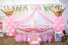 a pink princess birthday party with balloons, cake and tiara on the head table