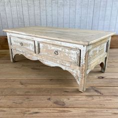 an old white coffee table with two drawers on one side and three drawers on the other