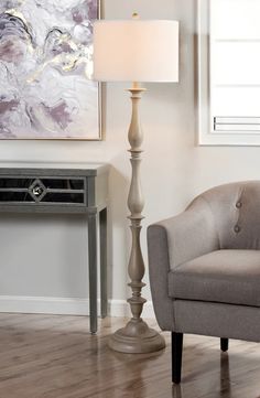 a living room with a chair, lamp and painting on the wall