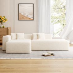 a white couch sitting on top of a hard wood floor next to a wooden dresser