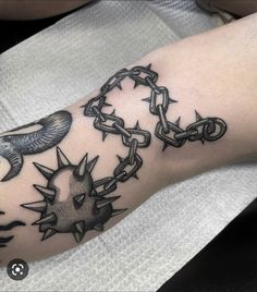 a person with a tattoo on their arm that has chains and birds attached to it