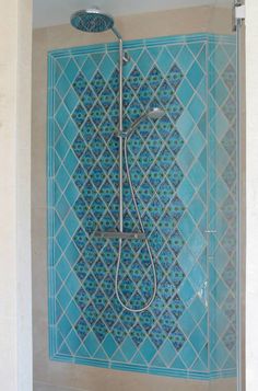 a shower with blue tiles in a bathroom