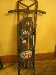 an old fashioned sled with a snowman painted on it