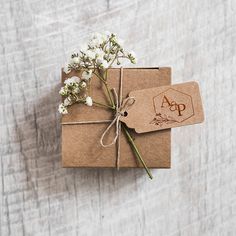 two brown packages tied up with twine and some white flowers on top of them