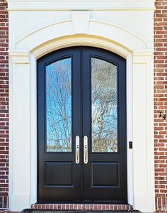 a black double door with two sidelights on brick building