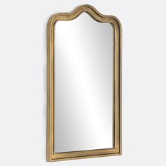 a gold framed mirror on the wall