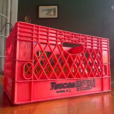 a red crate sitting on top of a wooden floor