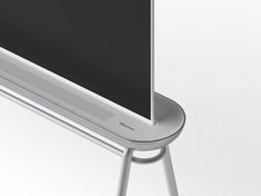 a flat screen tv mounted to the side of a metal stand with an electronic device on it