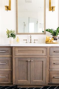 a bathroom vanity with two sinks and mirrors