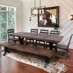 a dining room table and bench in front of a window with a horse painting on the wall