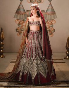 The kokum sherbet lehenga is a grand choice for the bride who wants to stand out. Featuring tissue inlays adorned with son parni, kusum kali, and saad barg motifs, it is complemented by an intricately embroidered red and wine dupatta in a geometric layout. An additional optional heavy naga-tikki embroidered dupatta completes this timeless ensemble, which also includes a separate cancan. Elegant Ceremonial Lehenga With Dabka Work, Ceremonial Lehenga With Dabka Work For Eid, Ceremonial Dola Silk Lehenga For Eid, Ceremonial Lehenga With Dabka Work For Festivals, Ceremonial Lehenga With Dabka Work For Diwali, Ceremonial Bollywood Choli With Dabka Work, Anarkali Style Ceremonial Sharara With Dabka Work, Bollywood Ceremonial Choli With Dabka Work, Bollywood Style Choli With Dabka Work For Ceremonial Occasions