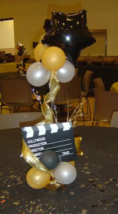 a table with balloons and a clap board on it