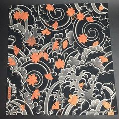 an orange and black paper with flowers on it