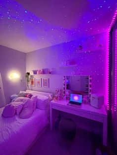 a bedroom with purple lights on the ceiling and a white bed in front of a computer desk