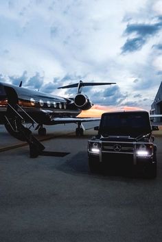 an suv is parked in front of a private jet and a plane on the tarmac