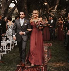 a bride and groom walking down the aisle