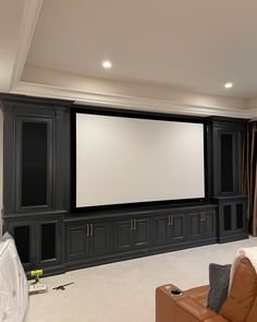 an empty living room with a large screen on the wall