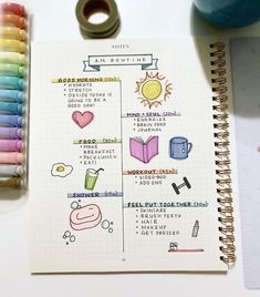 an open notebook with colored pencils next to it