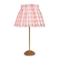 a pink and white checkered lamp shade on a wooden base with a light bulb